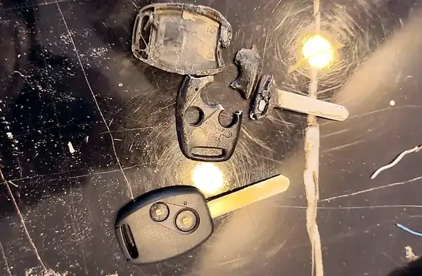 Honda remote key with a shell broken into pieces (top) and the same key rebuilt in a new shell (bottom), repaired by Carkey Masters